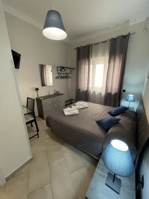 Neptune Room | Trastevere & Gianicolo Sweet Rest, Roma. Camera matrimoniale con bagno privato in camera con vista giardino interno, offre prodotti da bagno, bidet, WC, doccia, asciugamani, asciugacapelli, cucina attrezzata, piano cottura, forno, microonde, macchina da caffè, Tv, Netflix.