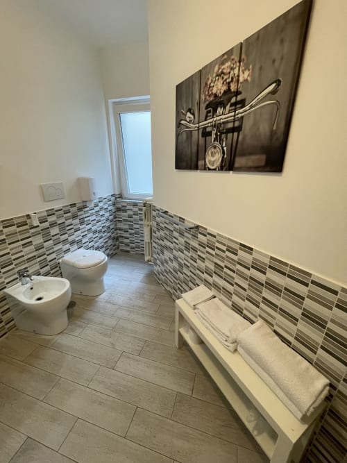 Elengance Room | Trastevere Sweet Rest, Roma. Camera tripla con balcone dotata di bagno privato esterno, prodotti da bagno, bidet, doccia, asciugamani, asciugacapelli, cucina, lavatrice, zona pranzo, zona soggiorno, TV a schermo piatto, vista cortile interno.