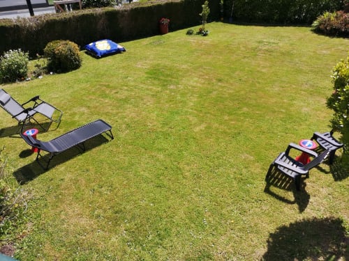 Sunny backyard at Au Gite d'Isigny with lounge chairs, blue inflatable pool, and manicured lawn in Isigny-sur-Mer