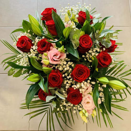 Elegant floral bouquet with red roses, pink flowers, white baby's breath, and green foliage at Locations Loc'Maria,