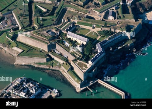 Aerial view of a medieval fortress and hotel on Belle Île en Mer, France, surrounded by turquoise waters and fortified walls