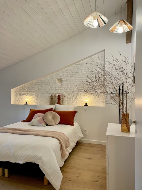 Modern attic bedroom at Maison Monsieur Léger in Montaut with white brick, pendant lights, burgundy accents