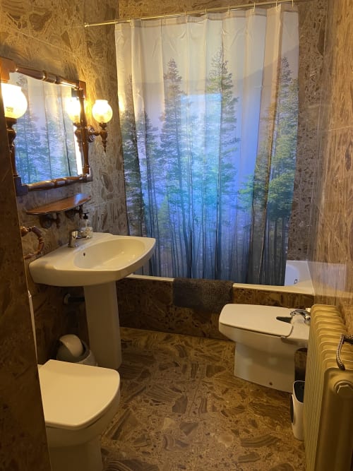 Baño moderno en Chalets Junto A Puy Du Fou con cortina de ducha bosque, lavabo pedestal, inodoro y piso de baldosas beige