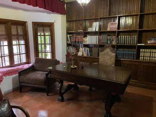 Elegante biblioteca de estudio con escritorio de madera oscura, estanterías y cómodos asientos en Esuri Chalet cerca de Puy Du Fou, Argés
