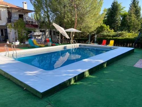 Piscina privada al aire libre en Chalet Esuri cerca de Puy Du Fou en Argés, España, con tumbonas, sombrillas, bbq y árboles del campo