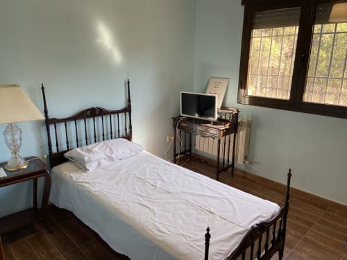 Dormitorio con 2 camas de madera, lámpara de noche y ventanas con vistas a las montañas en Chalet Dani.
