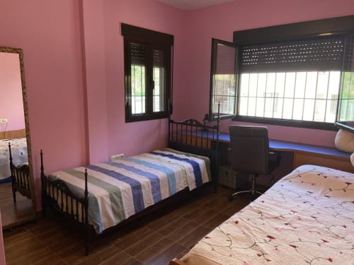 Dormitorio rosa brillante con dos camas de madera, ventanas en Chalet Dani cerca de Puy Du Fou, Argés