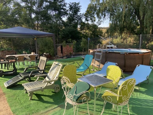Área de piscina privadaal aire libre en chalet Dani cerca de Puy Du Fou con tumbonas, sombrillas y cenador.