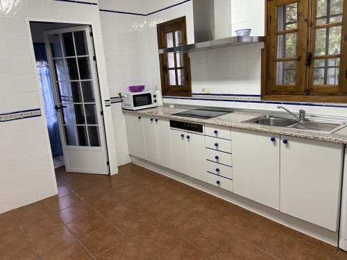 Cocina equipada en la cabaña de Chalets Junto A Puy Du Fou con muebles blancos, encimera de granito y electrodomésticos modernos