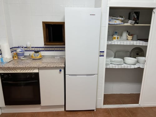 Cocina equipada en la cabaña Chalets Junto A Puy Du Fou con refrigerador, horno y almacenamiento de vajilla