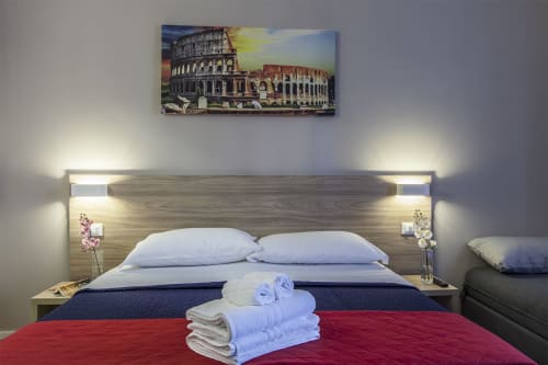 Camera Colosseo | B&B La Palma, Roma. Letto matrimoniale moderno, arredi tradizione romana. Ideale per coppie. Servizi: doccia emozionale, climatizzazione, Wifi, scrivania, bagno privato, asciugamani, aria condizionata, TV, finestra, parcheggio, pet friendly.