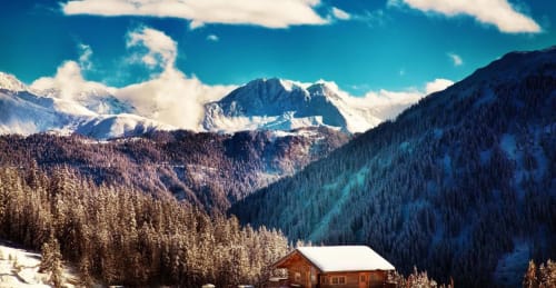 Le lodge Couleurs Montagne niché dans la vallée enneigée de Valloire avec pics alpins et forêts givrées