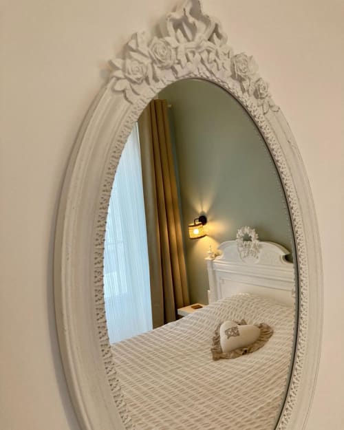 Miroir blanc ovale orné reflétant la chambre de La Maison Virginie, gîte à Montargis