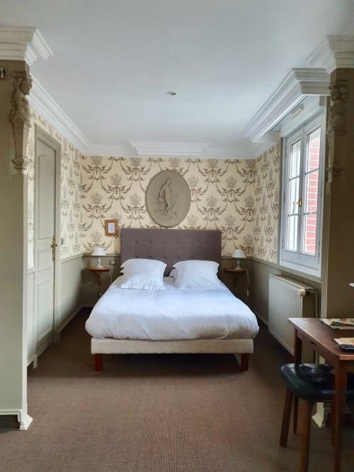 Chambre supérieure de l'hôtel Les Cabines à Houlgate avec lit queen-size, papier peint damassé et vue sur la ville