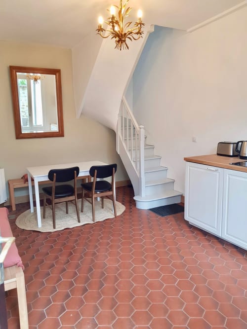 Salle à manger de la villa Les Cabines avec escalier, carrelage hexagonal de la terrasse et mobilier contemporain à Houlgate