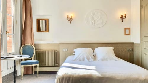 Chambre élégante de l'hôtel Les Cabines à Houlgate, décor classique, literie blanche et mobilier d'époque