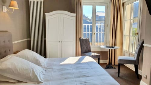 Chambre lumineuse à l'hôtel Les Cabines à Houlgate avec vue sur mer, armoire blanche et charme côtier