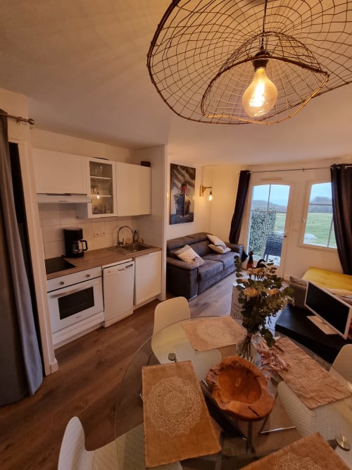 Appartement moderne à Belle Île en Mer avec cuisine ouverte, salle à manger, canapé et vue sur mer