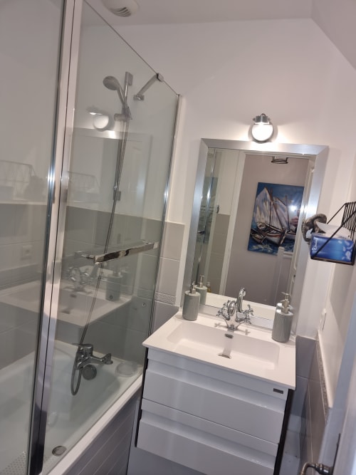 Salle de bains moderne avec vasque blanche, miroir et douche à l'italienne à l'appartement Loc'Maria, Belle Île, France
