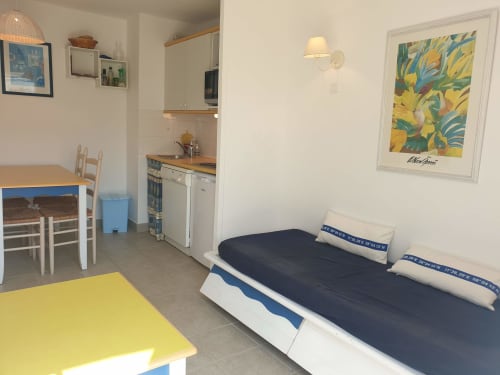 Lumineux studio à Belle-île-en-Mer avec lit, table à manger, kitchenette et œuvres colorées