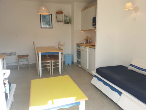 Studio à Loc'Maria Belle Île avec lit, table à manger, cuisine et table jaune dans le séjour