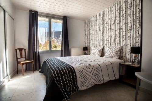 Bright bedroom at Au Gite d'Isigny cottage in Isigny-sur-Mer with patterned bedding, garden view windows, and modern