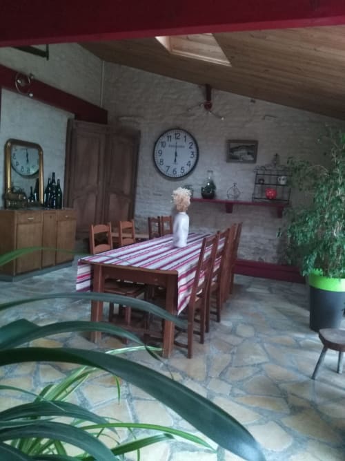  Grande salle commune de la maison d'hôtes La Chabanaise en Marais Poitevin : murs en pierres apparentes, table conviviale pour les petits-déjeuners et décoration rustique avec meubles anciens.