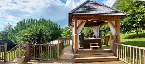 Houten prieel met hot tub bij gîte Domaine De Campagnac in Carsac-Aillac, omgeven door verzorgde tuinen