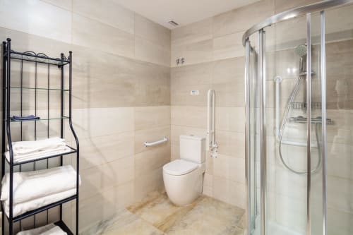 Banheiro moderno na Pousada O Trancallo com chuveiro walk-in, sanitário e toalheiro em Ourense
