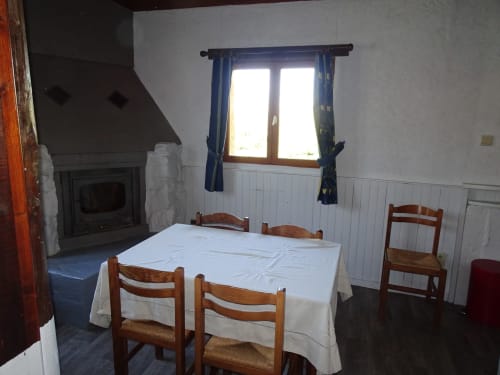 Un espace repas exposé plein sud et sa cheminée pour un séjour en hiver.