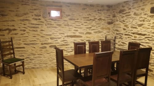 Salle à manger en pierre avec table et chaises en bois à O Trancallo BnB à Mourisca, Ourense, Espagne