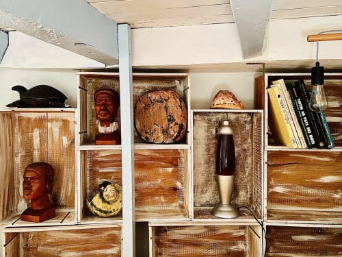 Décoration personnalisée du studio : étagères artisanales en caisses de bois, livres et objets d'art pour se sentir comme à la maison.