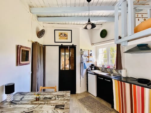 Intérieur du studio au Moulin de Pascale : canapé confortable, table basse et mezzanine de couchage dans une ambiance lumineuse.