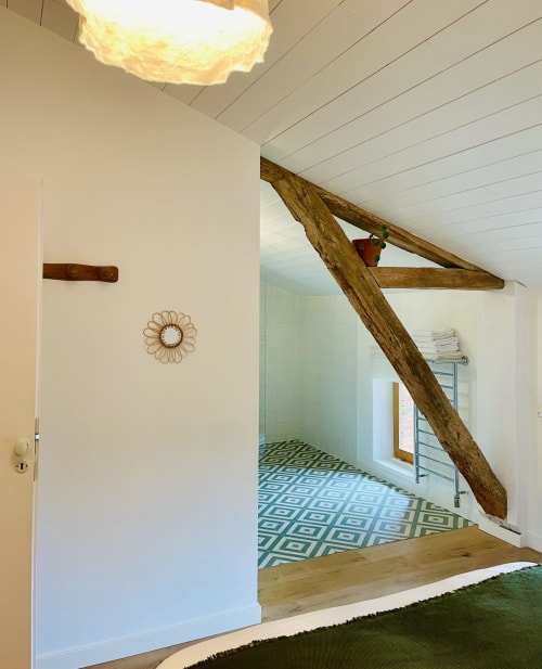 Chambre Coton à la Maison Monsieur Léger avec poutres apparentes, murs blancs et carrelage géométrique bleu dans la salle de bain