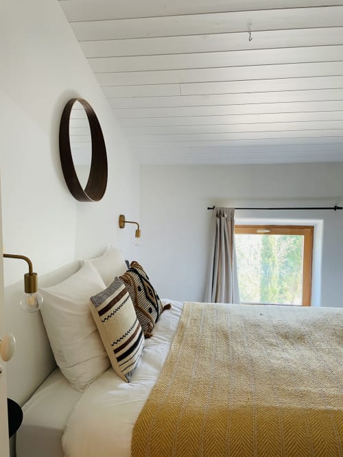 Chambre Bulle à la Maison Monsieur Léger avec literie crème, coussin à motifs, miroir ovale et vue sur le jardin