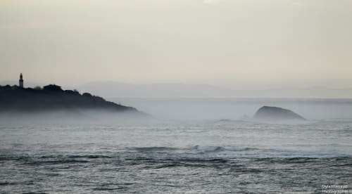 Le Phare de Biarritz émergeant de la brume océanique, ambiance mystique et sauvage sur le littoral basque.