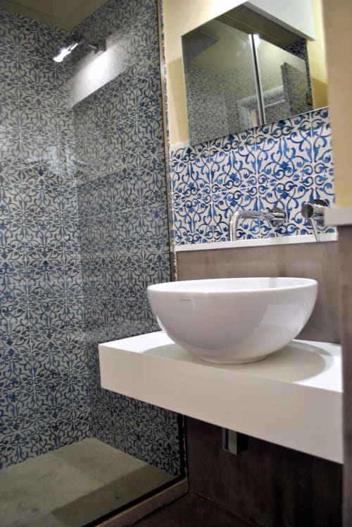 Bagno moderno a Villa Blanche Holidays con piastrelle blu decorate, lavabo bianco e specchio a Marsala, Sicilia