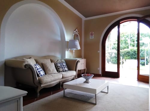 Elegante soggiorno di Villa Blanche Holidays a Marsala con soffitti a volta, divano beige e pavimenti in cotto