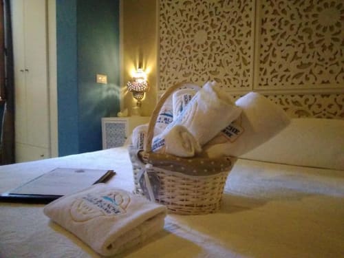 Elegante camera d'albergo a Villa Blanche con cesto benvenuta, servizi e pannelli murali decorativi a Marsala