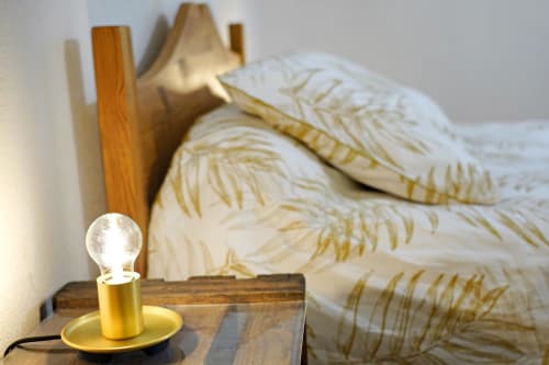 Lámpara de mesita de noche cálida con bombilla dorada junto a una almohada blanca de plumas en la habitación Chanterelle en L'étape Du Fanfoué, Chamrousse