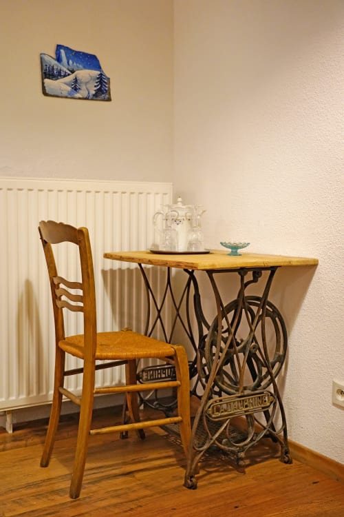 Vintage sewing machine desk with wooden chair in Girole room at L'étape Du Fanfoué, Chamrousse
