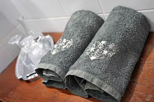 Rolled gray towels with decorative embroidery at L'étape Du Fanfoué, Chamrousse