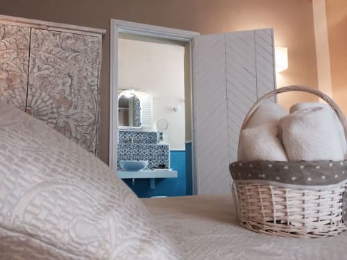 Camera Levanzo a Villa Blanche Holidays a Marsala con letto, cesto in vimini e vista sul bagno