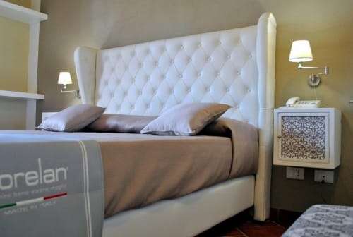 Camera di lusso a Villa Blanche Holidays a Marsala con testata capitonné bianca, biancheria marrone e servizi moderni