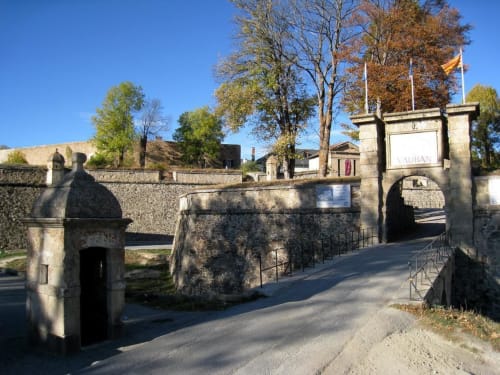 Entrée de forteresse en pierre avec pont-levis aux Gites Mas D'en Ratéro à Thuir, France, arbres d'automne visibles