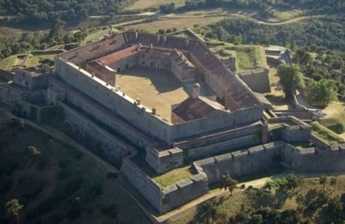 Vue aérienne de la forteresse Gîtes Mas D'en Ratéro à Thuir, France, entourée de verdoyantes campagnes