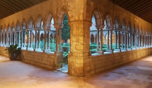 Cloître médiéval aux colonnes voûtées et jardin de cour aux Gites Mas D'en Ratéro, Thuir France