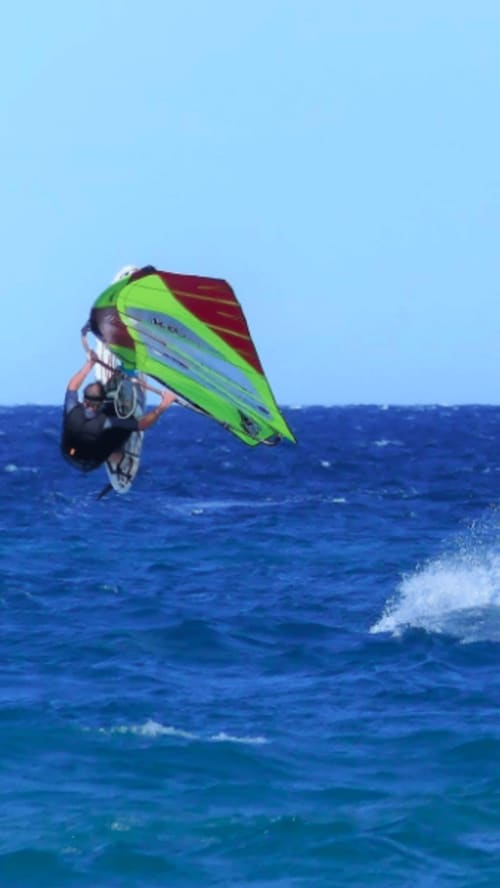 Véliplanchiste avec voile vert citron chevauchant les vagues près de Thuir, France