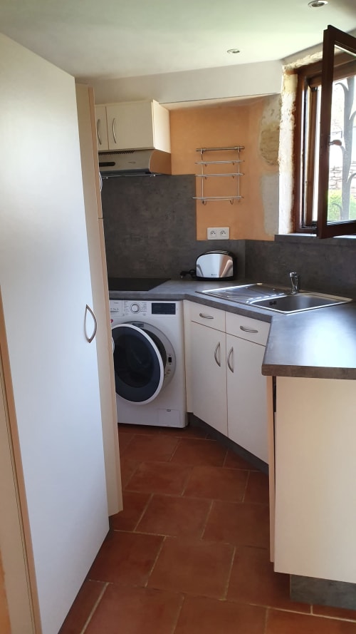 Fully equipped kitchen of Cristal Cottage with washing machine, dishwasher and park view.