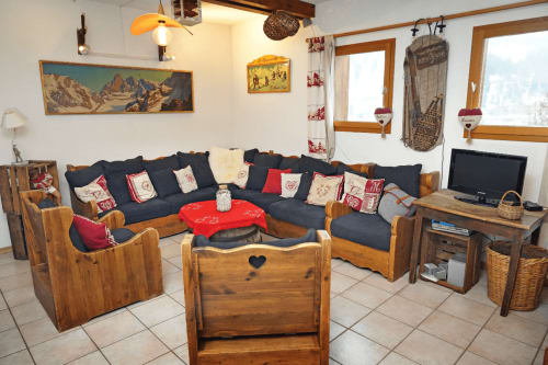 Salon alpin douillet à L'étape Du Fanfoué à Chamrousse avec mobilier en bois, canapé bleu marine et décor rustique
